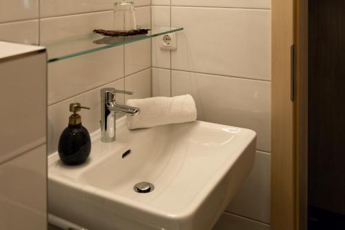 ein Waschbecken im Bad mit einem Glasregal darüber in der Unterkunft Chesa Platina in Schruns-Tschagguns