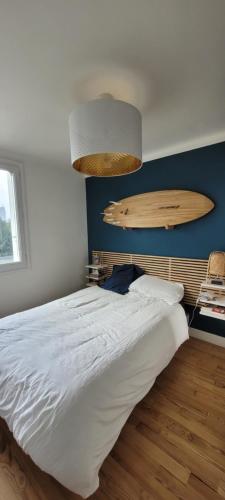 - une chambre avec un lit et une planche de surf sur le mur dans l'établissement T2 vue Cathédrale de Nantes, à Nantes