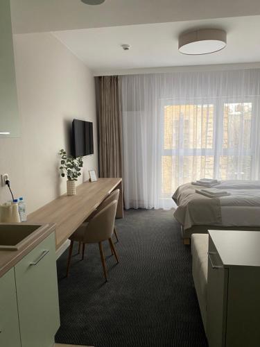 a hotel room with a desk and a bed at Apartamenty Wolności 6 self check-in 24h in Poznań