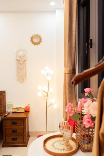 a living room with a table and flowers on the floor at The Sophia Apartment - Thao Dien Central in Ho Chi Minh City