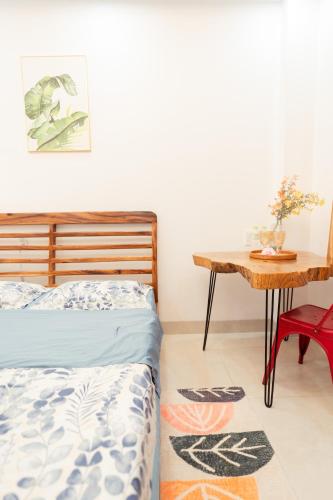 a bedroom with a bed and a table at The Sophia Apartment - Thao Dien Central in Ho Chi Minh City