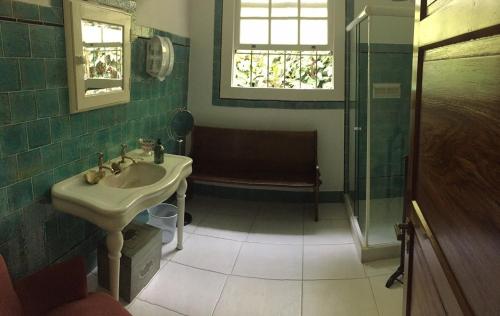 uma casa de banho com um lavatório e um chuveiro em Casa Vila Brasil - Centro Histórico em Petrópolis