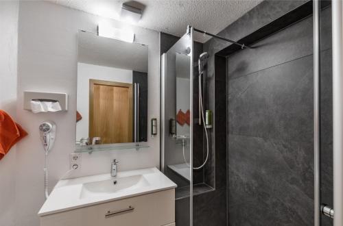 a bathroom with a sink and a shower at Bodensee Hotel Storchen in Uhldingen-Mühlhofen