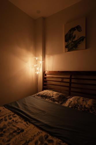 a bedroom with a bed and a light on the wall at The Sophia Apartment - Thao Dien Central in Ho Chi Minh City