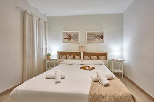a bedroom with a large white bed with two towels at BBarcelona Encants Flat in Barcelona