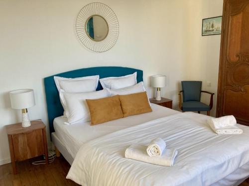 une chambre avec un grand lit avec des serviettes dessus dans l'établissement Les Penates, à Veules-les-Roses