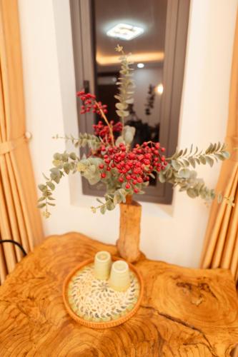 a vase with flowers in it on a table at The Sophia Apartment - Thao Dien Central in Ho Chi Minh City