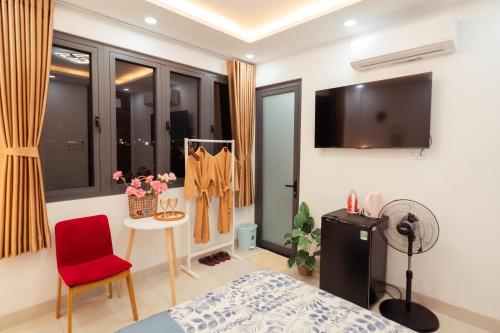 a bedroom with a bed and a red chair at The Sophia Apartment - Thao Dien Central in Ho Chi Minh City