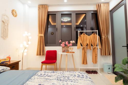 a bedroom with a bed and a red chair at The Sophia Apartment - Thao Dien Central in Ho Chi Minh City