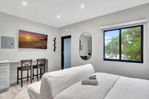 een witte slaapkamer met een bed en een tafel en stoelen bij Studio Right off Las Olas - Steps to FTL Beach 2C in Fort Lauderdale