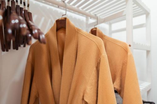 a row of coats hanging on a rack at The Sophia Apartment - Thao Dien Central in Ho Chi Minh City