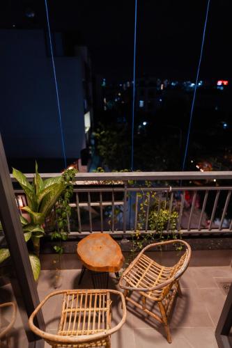 two chairs and a table on a balcony at night at The Sophia Apartment - Thao Dien Central in Ho Chi Minh City
