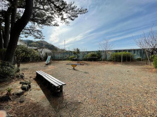 a park with a bench and a picnic table at 源泉かけ流しの露天風呂を独り占め！一棟貸切旅館「御宿あさか」29名まで宿泊可 in Ena