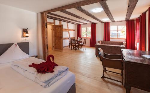una camera da letto con un letto con un nastro rosso sopra di Bodensee Hotel Storchen a Uhldingen-Mühlhofen