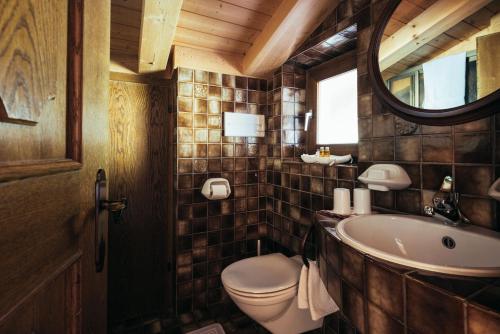 a bathroom with a toilet and a sink and a mirror at Haus Elisabeth in Santa Gertrude nella Val d'Ultimo