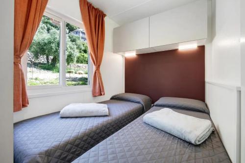Camping Eurovil في بريدور: غرفة نوم بسريرين ونافذة