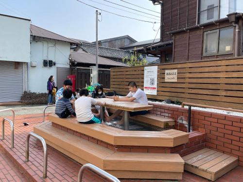 a group of people sitting at a picnic table at 源泉かけ流しの露天風呂を独り占め！一棟貸切旅館「御宿あさか」29名まで宿泊可 in Ena