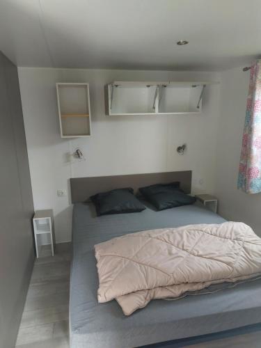 een slaapkamer met een bed in een kleine kamer bij Mobil home 7 couchages in Ouistreham
