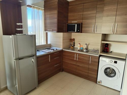 uma cozinha com um frigorífico e uma máquina de lavar roupa em Апартаменты в Belvedere em Bansko