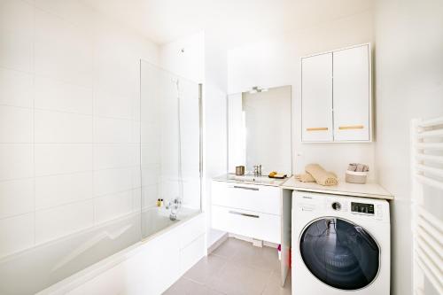 W białej łazience znajduje się pralka. w obiekcie Appartement T2 neuf - Grande Terrasse de 25m2 w mieście Saint-Priest