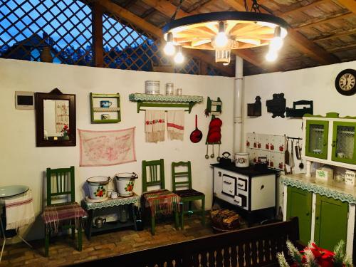 a room with chairs and a table and a stove at Mátrai pincés udvar in Mátramindszent