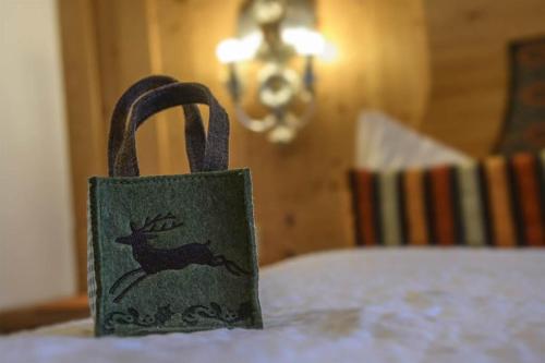 a green bag with a deer on it sitting on a table at Alpasella Ferienwohnungen in Sankt Gallenkirch