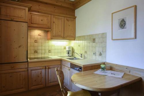 a kitchen with wooden cabinets and a wooden table at Alpasella Ferienwohnungen in Sankt Gallenkirch