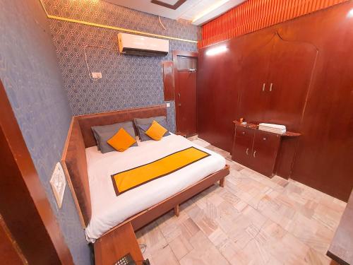 a bedroom with a bed with orange and yellow pillows at Lucky Restaurant & Guest House in Agra