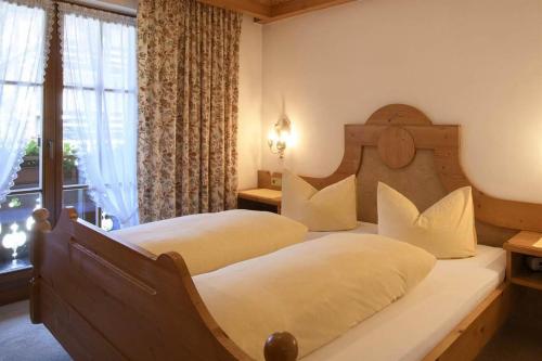 a hotel room with two beds and a window at Alpasella Ferienwohnungen in Sankt Gallenkirch