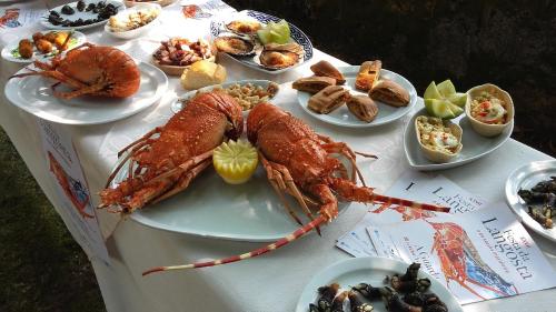 a table with lobster and other dishes of food at A Las faldas del Tecla in A Guarda