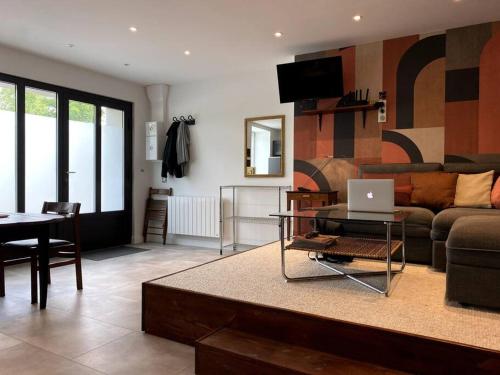 uma sala de estar com um sofá e uma mesa com um computador portátil em Le nuage des balmes em Caluire-et-Cuire