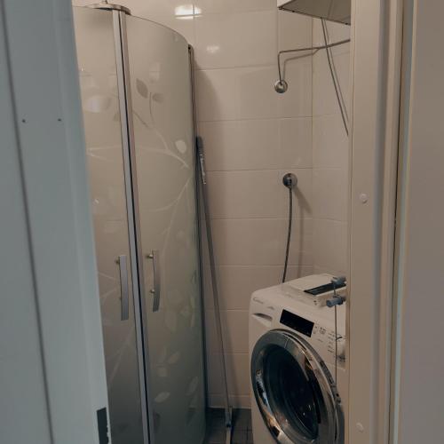 een wasmachine in een badkamer met een glazen deur bij Villa Niva in Rovaniemi