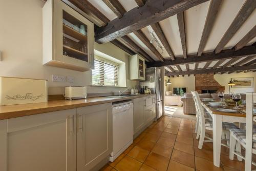 a kitchen with a table and a dining room at The Granary in Oulton