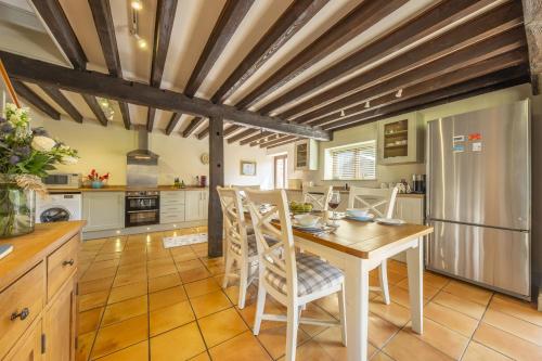 a kitchen with a table and chairs and a refrigerator at The Granary in Oulton
