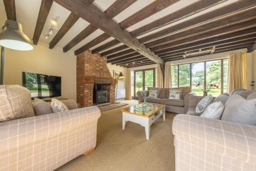 a living room with couches and a fireplace at The Granary in Oulton