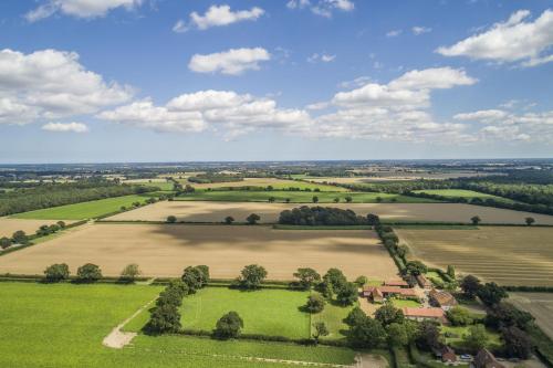 an aerial view of a field with trees in the middle at The Granary in Oulton
