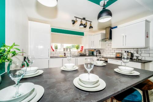 a kitchen with a table with wine glasses on it at Sleek and Stylish 3 Bed in Greenock - Sleeps 8 in Greenock