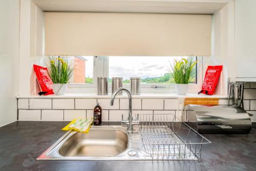 a kitchen sink with a dish drying rack next to a window at Sleek and Stylish 3 Bed in Greenock - Sleeps 8 in Greenock