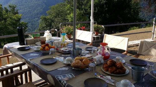 uma mesa com pratos de comida em cima de uma mesa em Bed and Breakfast Sanmichele em Druogno