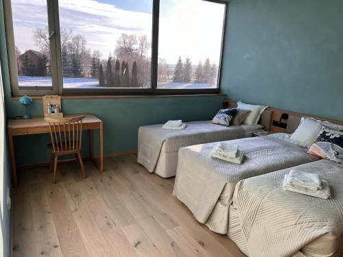 a room with two beds and a desk and two windows at LedowoHouse Industrial Style kids friendly in Lędowo
