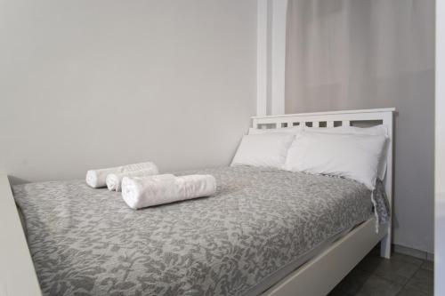 a white bed with two rolled towels on it at Andriana's studio in Parga