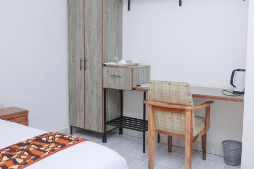 a bedroom with a desk and a chair and a bed at VIJIJI HOTEL & CONFERENCE in Eldoret