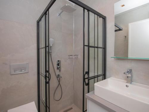una ducha con una puerta de cristal junto a un lavabo y un aseo en Asfiya Loft Apartments, en Kas