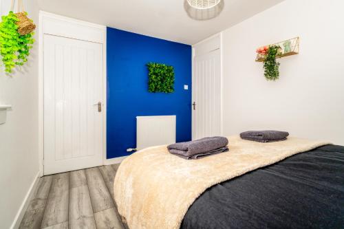 a bedroom with blue walls and a bed with two pillows at Sleek and Stylish 3 Bed in Greenock - Sleeps 8 in Greenock