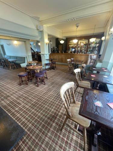 a dining room with tables and chairs and a bar at HQ Pencadlys in Prestatyn