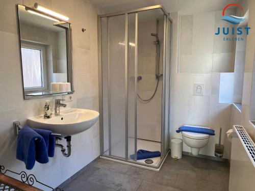 uma casa de banho com um chuveiro, um lavatório e um WC. em Pension Marie Luise 253 - Zimmer Meerschnecke em Juist
