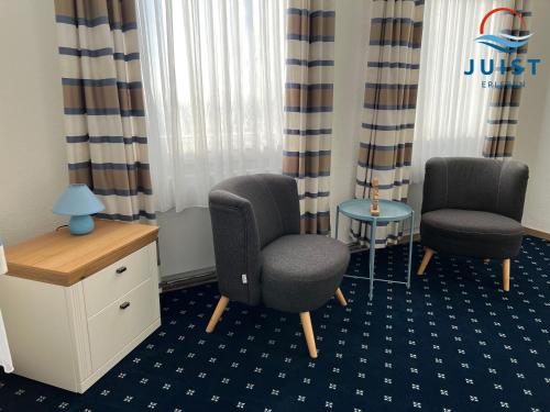 a room with two chairs and a desk and a table at Pension Marie Luise 253 - Zimmer Meerschnecke in Juist