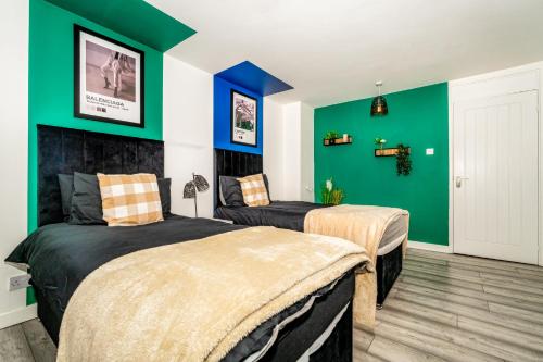a bedroom with two beds and green walls at Sleek and Stylish 3 Bed in Greenock - Sleeps 8 in Greenock