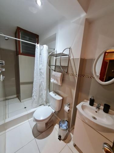 La salle de bains est pourvue de toilettes, d'un lavabo et d'un miroir. dans l'établissement Apartment Centric Inti 2, à Cusco