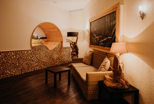 a living room with a couch and a mirror at Sonnenhotel Hoher Hahn in Schwarzenberg